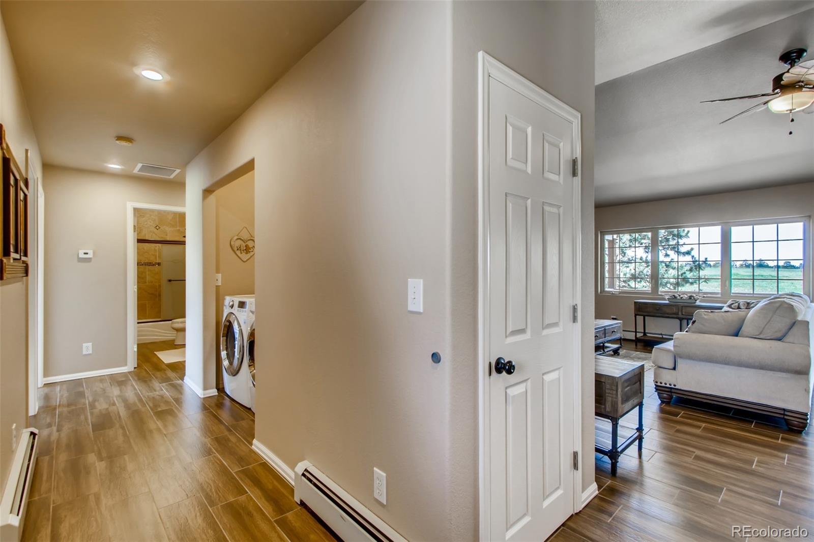 18030 Ranch Hand Road Peyton, CO 80831 - Photo 18 of 40 a view of a hallway with wooden floor and furniture