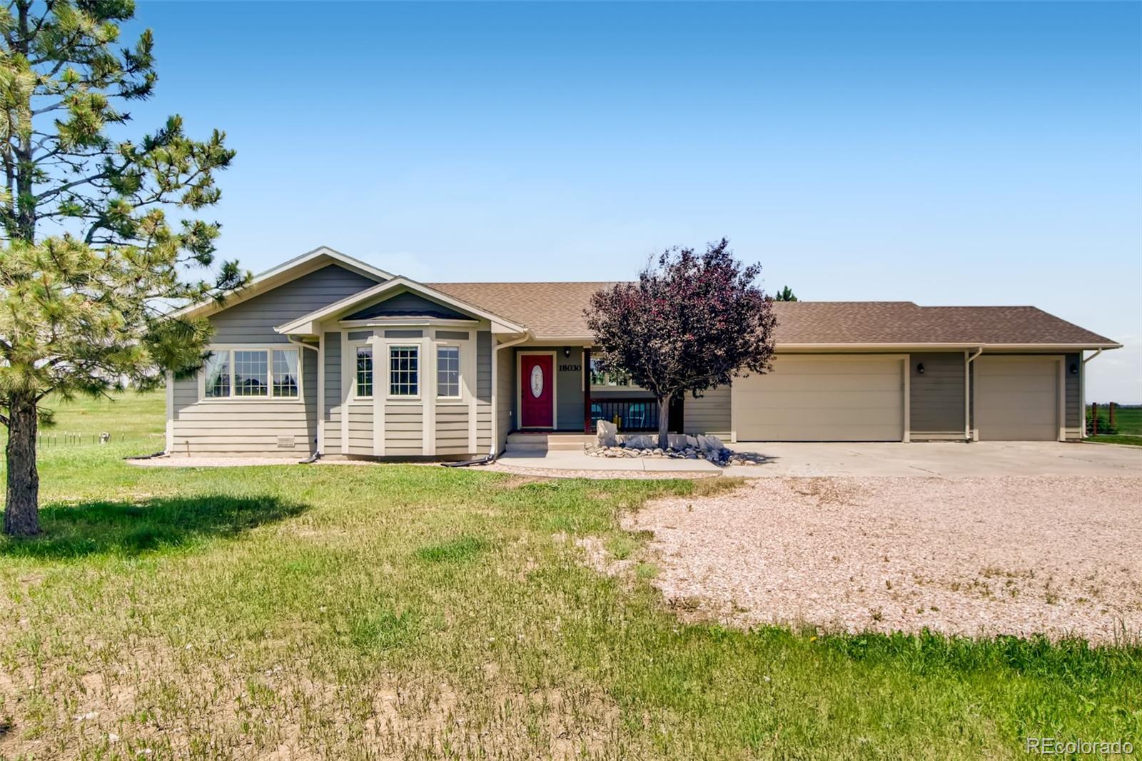 18030 Ranch Hand Road Peyton, CO 80831 - Photo 2 of 40 a front view of a house with a garden and yard