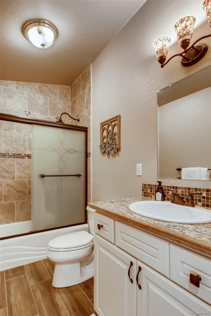 18030 Ranch Hand Road Peyton, CO 80831 - Photo 27 of 40 a bathroom with a sink a toilet and shower