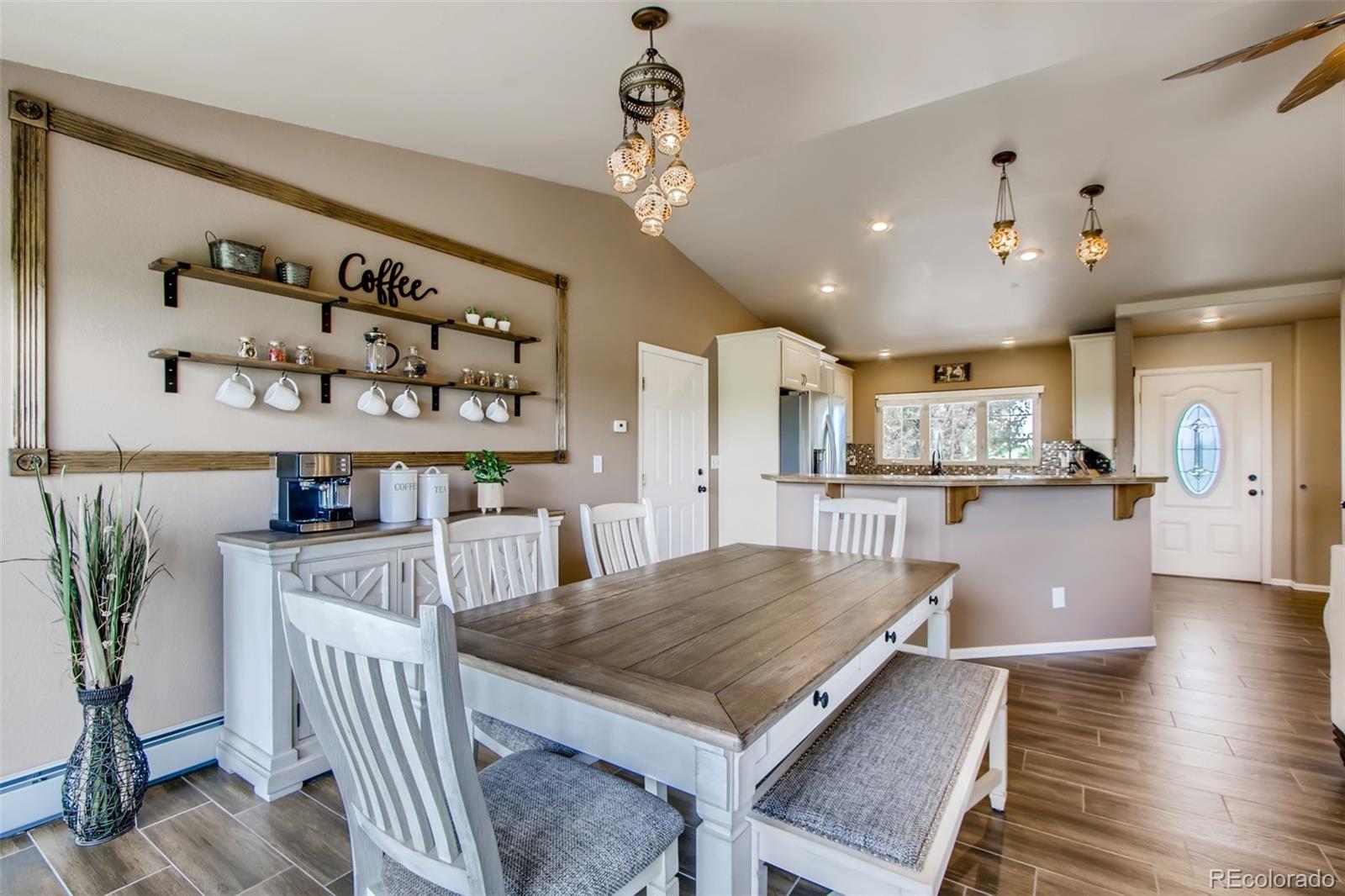 18030 Ranch Hand Road Peyton, CO 80831 - Photo 6 of 40 a living room with kitchen island furniture and a chandelier