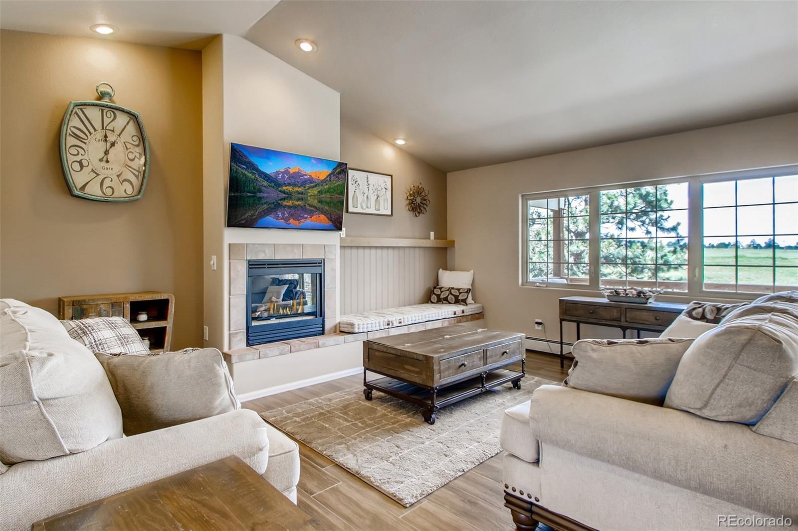 18030 Ranch Hand Road Peyton, CO 80831 - Photo 10 of 40 a living room with furniture a fireplace and a large window