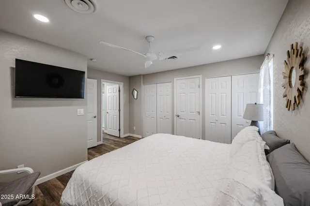 a spacious bedroom with a bed and a flat screen tv