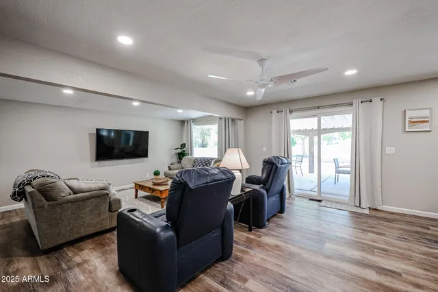 a living room with furniture a flat screen tv and wooden floor