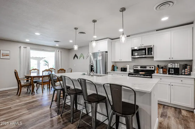 a large kitchen with kitchen island a sink appliances and a living room