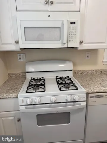 a stove top oven sitting inside of a kitchen
