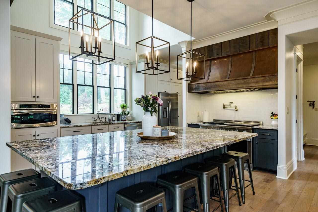 4709 Bountiful Lane Apex, NC 27539 - Photo 7 of 30 a kitchen with granite countertop a stove a sink and a wooden cabinets