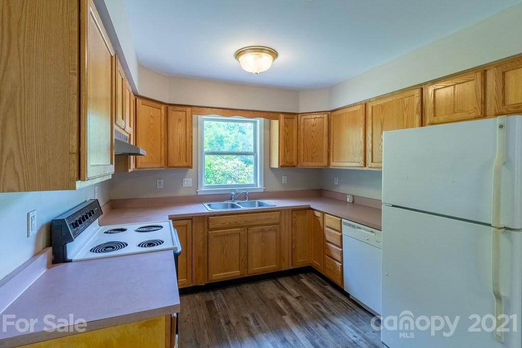 171 North Ridge Point, Unit V3 Sylva, NC 28779 - Photo 5 of 29 a kitchen with stainless steel appliances granite countertop a refrigerator a sink dishwasher a stove with wooden floor and cabinets