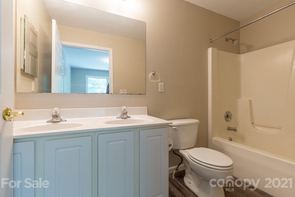 171 North Ridge Point, Unit V3 Sylva, NC 28779 - Photo 7 of 29 a bathroom with a toilet sink a mirror a vanity and shower