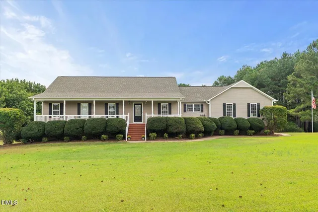 a front view of a house with yard and green space