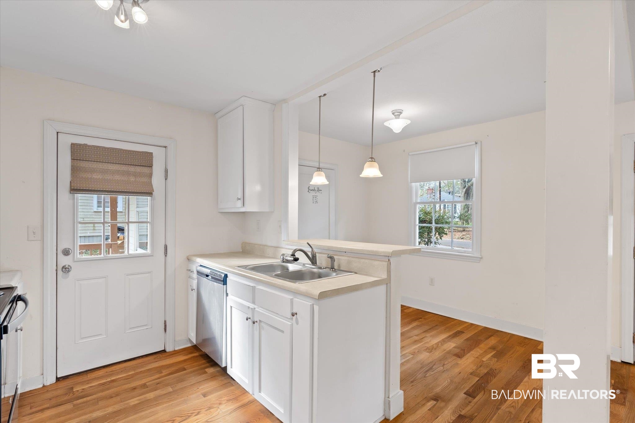 5113 Norton Lane Mobile, AL 36608 - Photo 5 of 20 Kitchen featuring appliances with stainless steel finishes, white cabinetry, a wealth of natural light, and sink