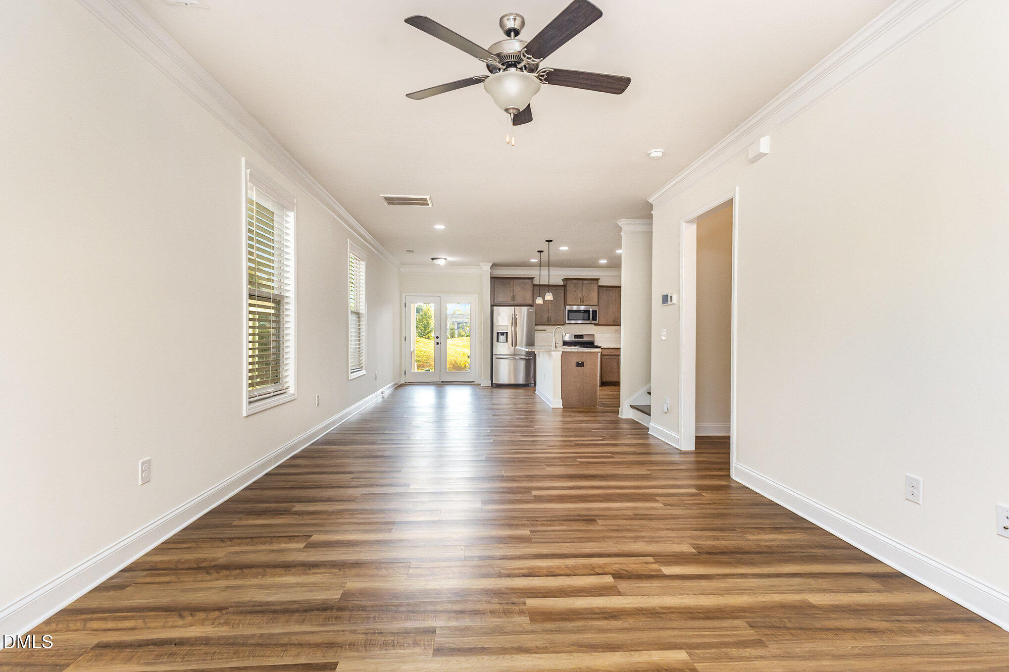824 Country Downs Road Wake Forest, NC 27587 - Photo 9 of 43 a view of an empty room with wooden floor and a ceiling fan