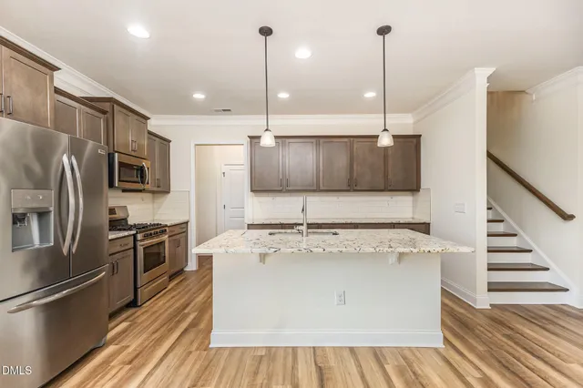 a view of kitchen with granite countertop cabinets and refrigerator