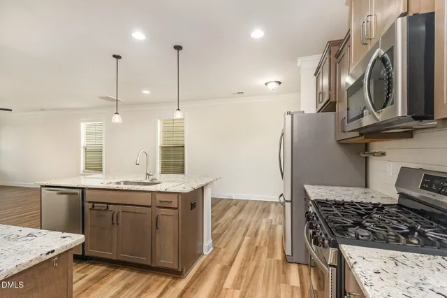 a kitchen with stainless steel appliances granite countertop a sink a stove and a refrigerator