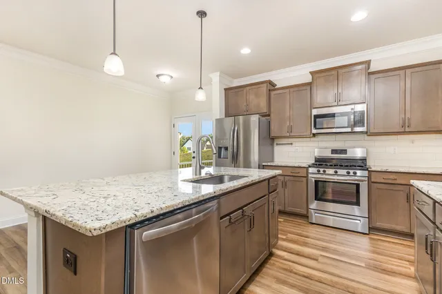 a kitchen with stainless steel appliances granite countertop a sink stove and refrigerator