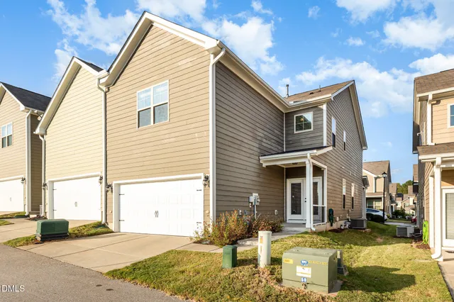 a view of a white house with a large windows and a yard