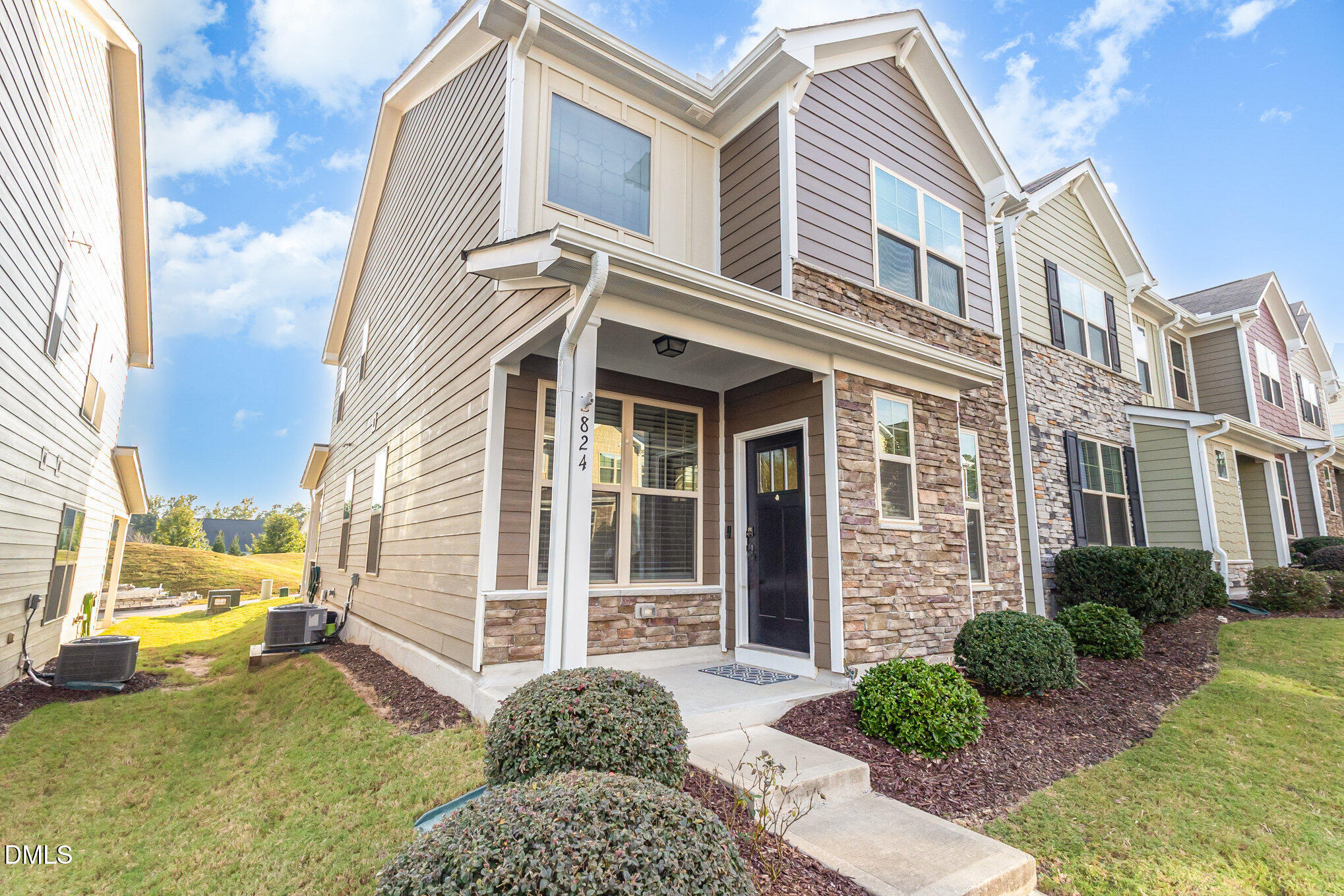 824 Country Downs Road Wake Forest, NC 27587 - Photo 5 of 43 a view of a brick house with many windows next to a yard