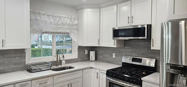 a kitchen with stainless steel appliances a sink stove and refrigerator