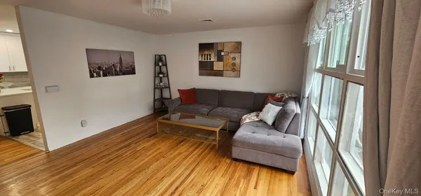 a living room with furniture a flat screen tv and a wooden floor