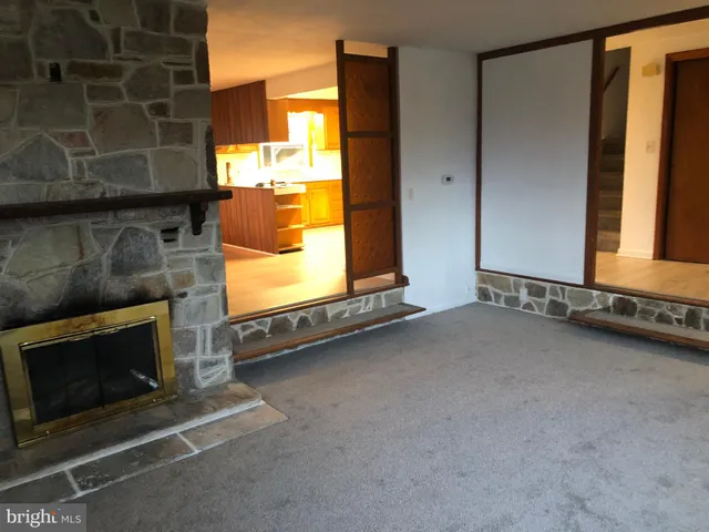 a view of an empty room with a fireplace and a window