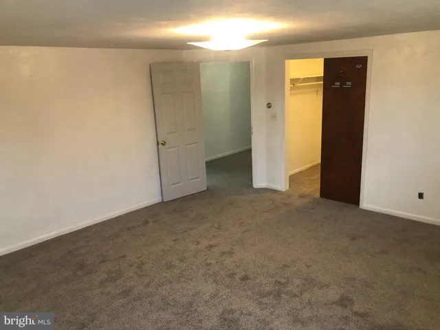 an empty room with closet and wooden door