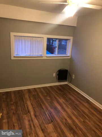 a room with a wooden floor and window