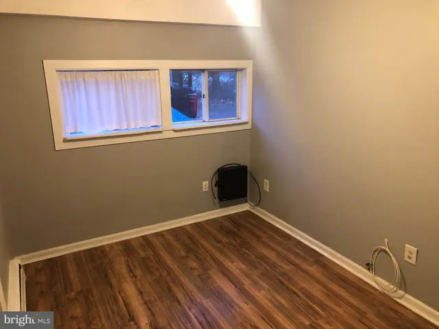 a view of small space with wooden floor and a window