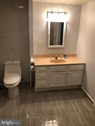 a bathroom with a toilet a sink and mirror