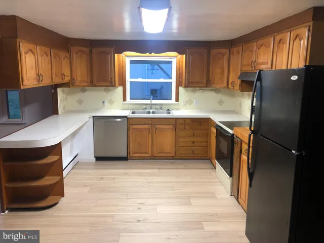 a kitchen with stainless steel appliances granite countertop a refrigerator a sink a stove and island