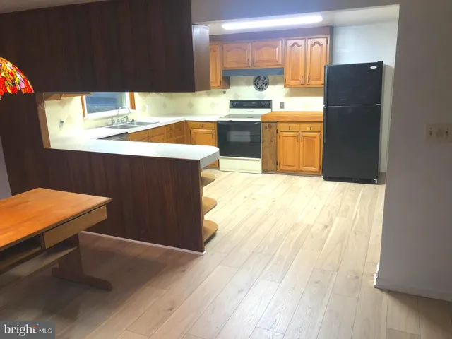 a kitchen with granite countertop a refrigerator and a stove top oven