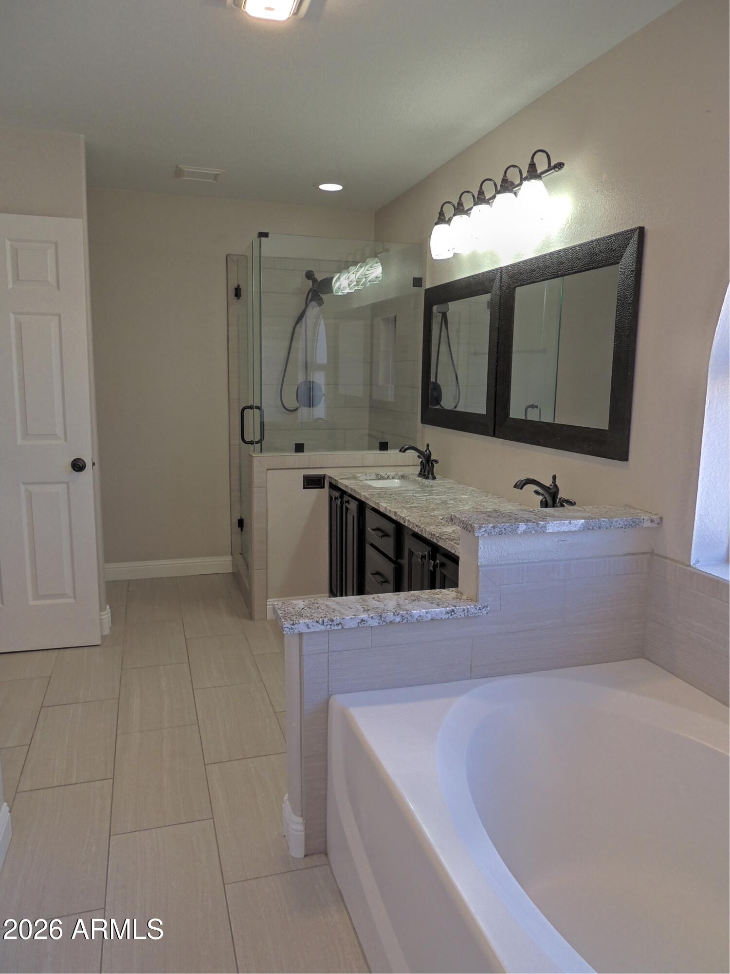 4409 East Dry Creek Road Phoenix, AZ 85044 - Photo 18 of 34 a bathroom with a tub sink and mirror