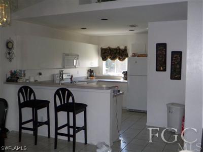 9024 Frank Road Fort Myers, FL 33967 - Photo 4 of 10 a kitchen with a dining table chairs and white cabinets