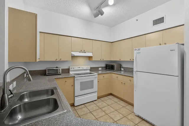 a kitchen with a stove a refrigerator and a sink