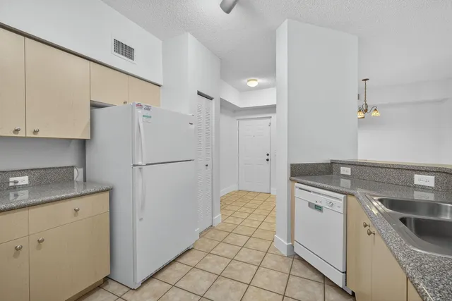 a kitchen with granite countertop white cabinets and white appliances