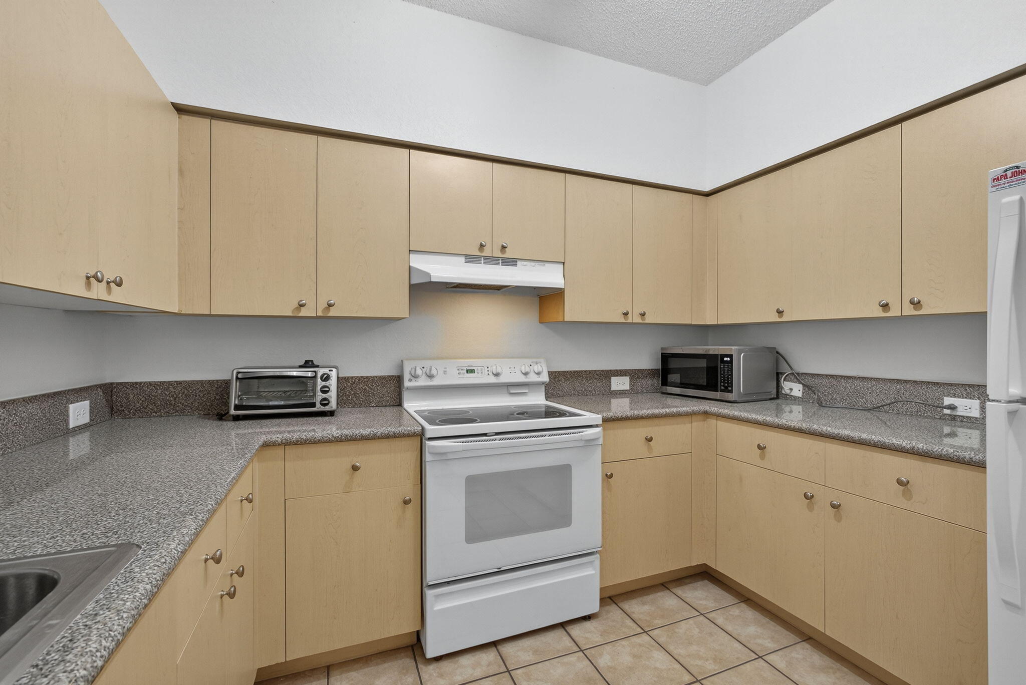 340 Crestwood Circle, Unit 201 Royal Palm Beach, FL 33411 - Photo 24 of 41 a kitchen with granite countertop white cabinets and white appliances