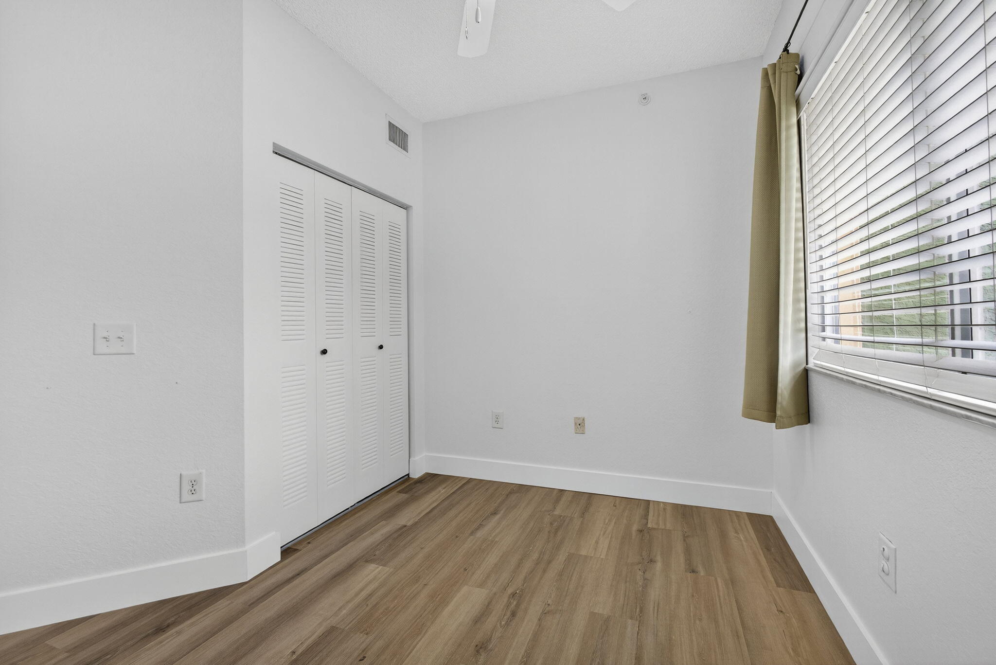 340 Crestwood Circle, Unit 201 Royal Palm Beach, FL 33411 - Photo 26 of 41 a view of an empty room with wooden floor and a window