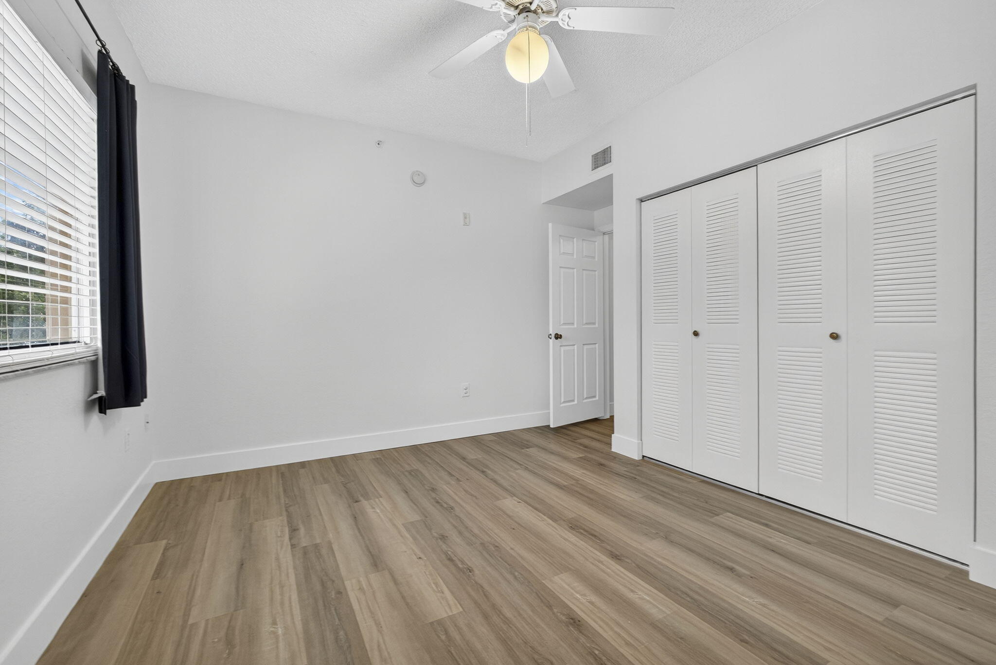 340 Crestwood Circle, Unit 201 Royal Palm Beach, FL 33411 - Photo 29 of 41 a view of an empty room with wooden floor and a window