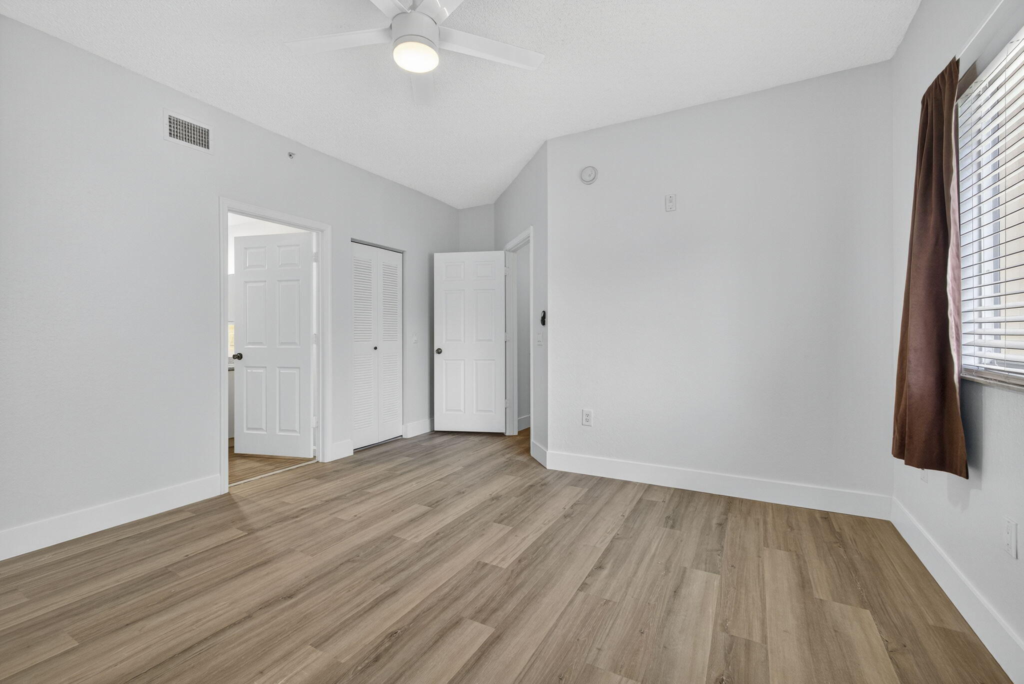 340 Crestwood Circle, Unit 201 Royal Palm Beach, FL 33411 - Photo 32 of 41 a view of an empty room with wooden floor and a window