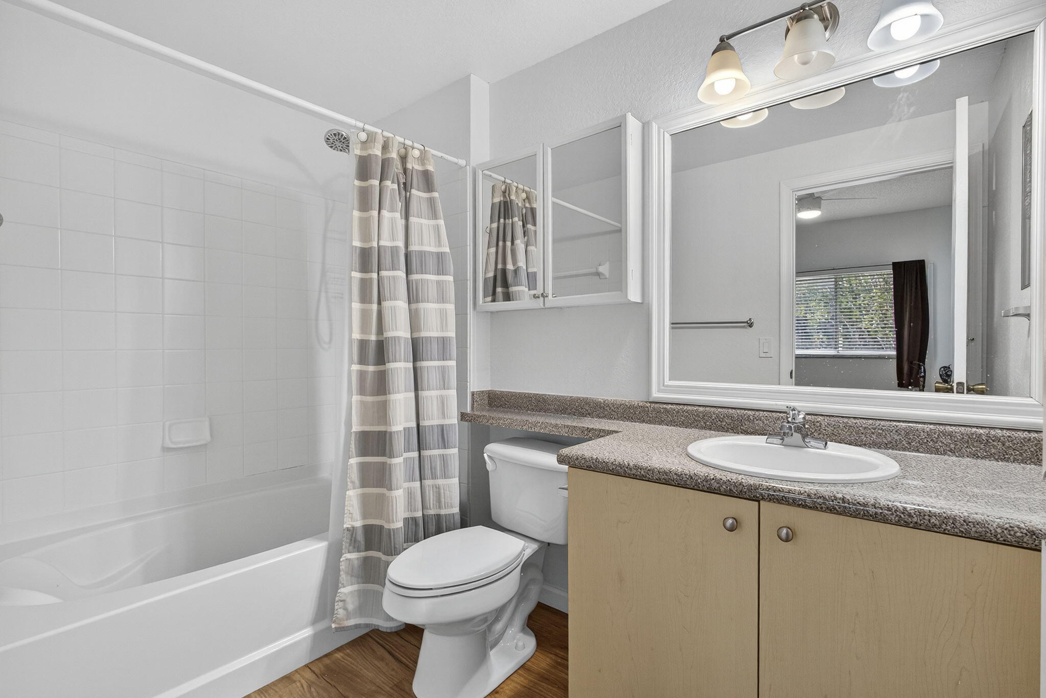 340 Crestwood Circle, Unit 201 Royal Palm Beach, FL 33411 - Photo 35 of 41 a bathroom with a granite countertop sink a toilet a mirror and bathtub