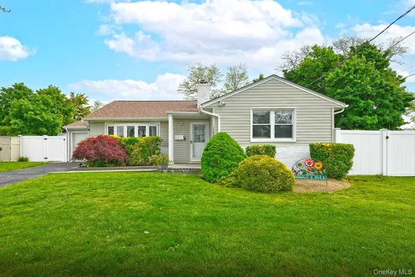 a view of a house with a yard and potted plants