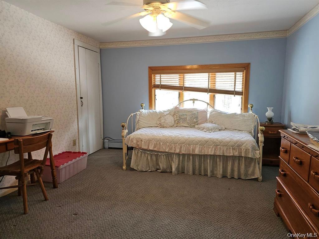 107 Eldred-Yulan Road Eldred, NY 12732 - Photo 22 of 24 a spacious bedroom with a bed and a chandelier