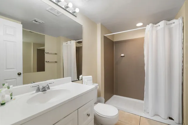 a bathroom with a sink a toilet and shower