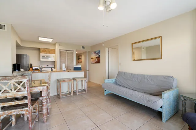 a living room with furniture and a dining table with kitchen view