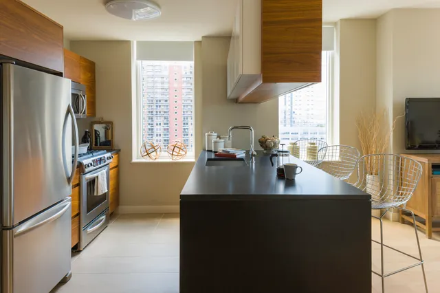 a kitchen with refrigerator a stove a sink a counter space and cabinets