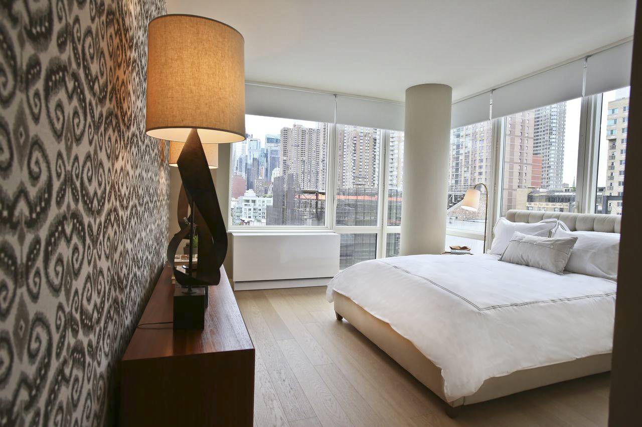 550 West 45th Street, Unit 2513 Manhattan, NY 10036 - Photo 3 of 22 a living room with a bed furniture and a large window