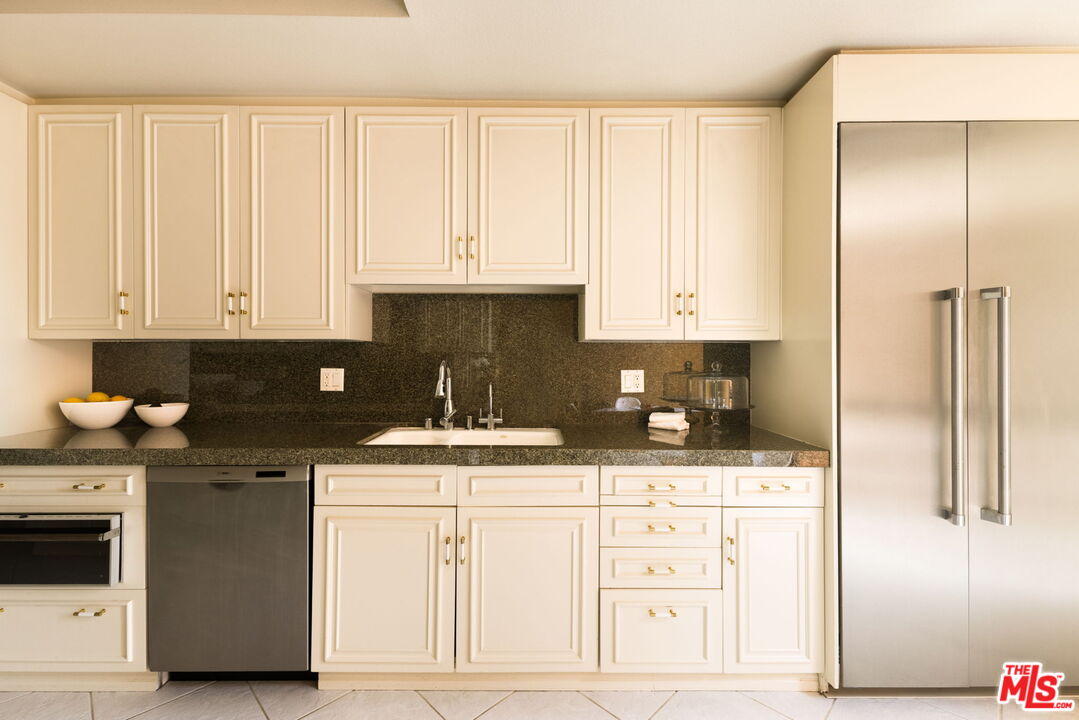 300 North Swall Drive, Unit 353 Beverly Hills, CA 90211 - Photo 13 of 31 a kitchen with stainless steel appliances granite countertop a stove a sink and white cabinets