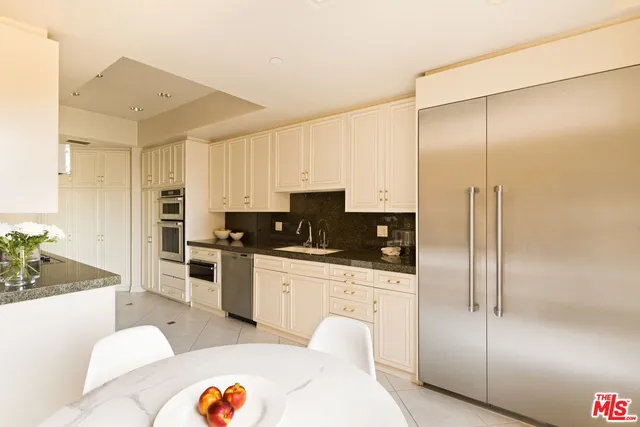 a kitchen with granite countertop white cabinets and stainless steel appliances