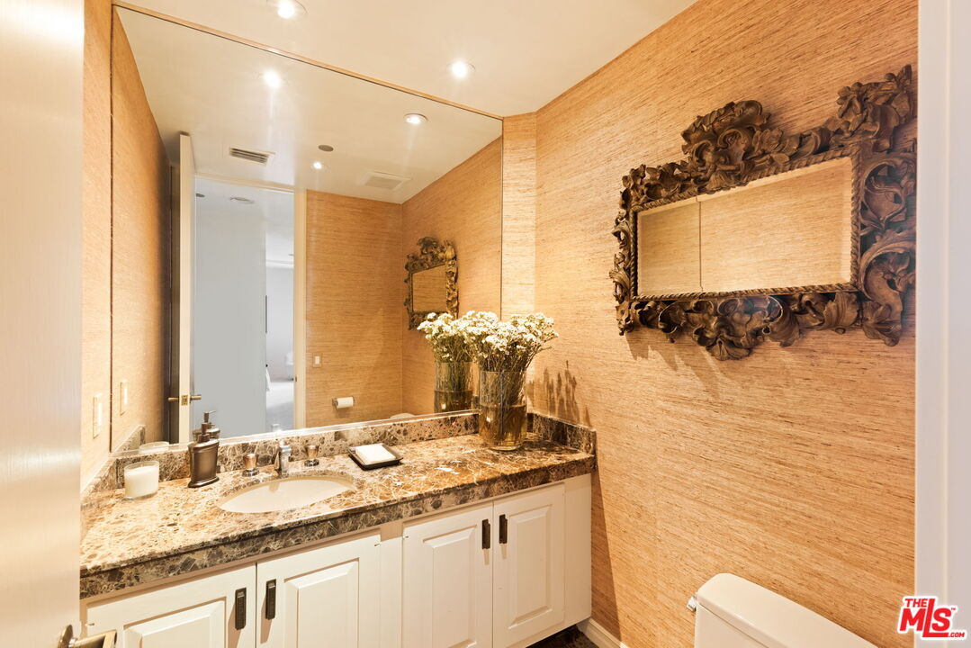 300 North Swall Drive, Unit 353 Beverly Hills, CA 90211 - Photo 17 of 31 a bathroom with a granite countertop sink and a mirror
