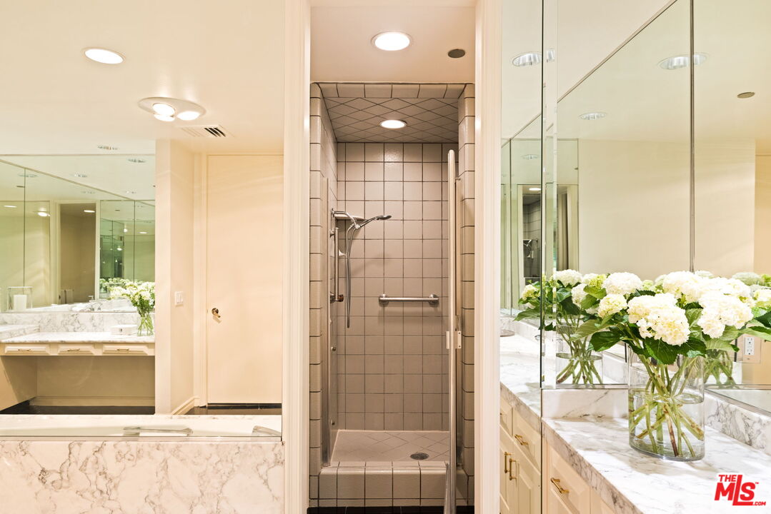 300 North Swall Drive, Unit 353 Beverly Hills, CA 90211 - Photo 22 of 31 a bathroom with a shower sink and mirror
