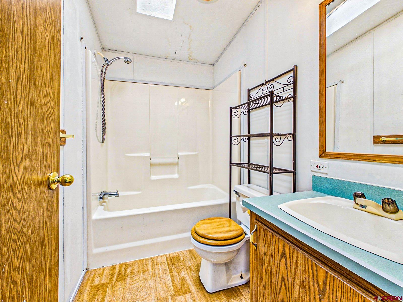 15484 Peach Road Cedaredge, CO 81413 - Photo 15 of 35 a bathroom with a granite countertop sink toilet and shower