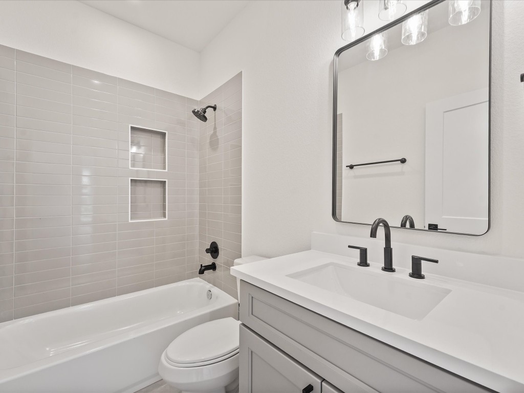 243 Rebecca Street, Unit F Houston, TX 77022 - Photo 20 of 26 a bathroom with a sink a toilet a mirror a bathtub and shower